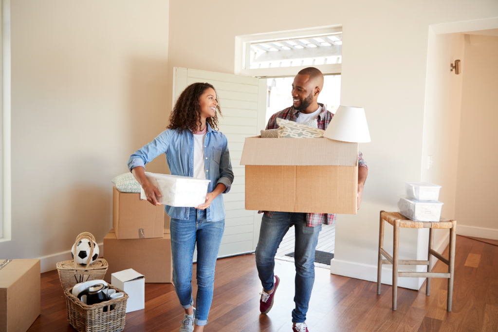 Couple Carrying Boxes Into New Home On Moving Day